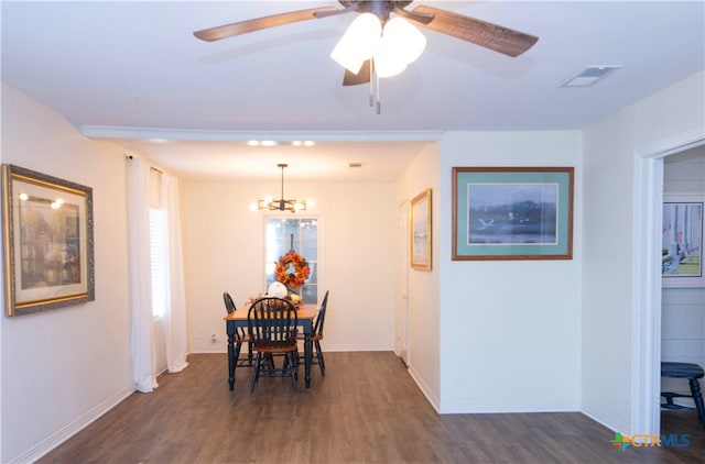 dining space featuring dark hardwood / wood-style flooring and ceiling fan with notable chandelier