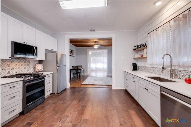 721 W Kings Hwy, San Antonio, TX 78212 - kitchen featuring stainless steel appliances, a sink, light countertops, backsplash, and white cabinetry
