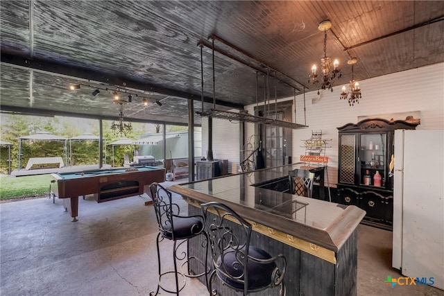 721 W Kings Hwy, San Antonio, TX 78212 - bar area with freestanding refrigerator, concrete flooring, billiards, a chandelier, and a wood stove