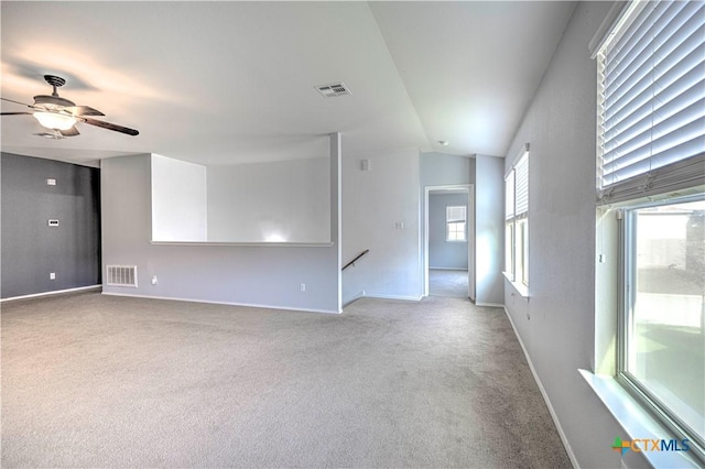 spare room with lofted ceiling, light carpet, and ceiling fan