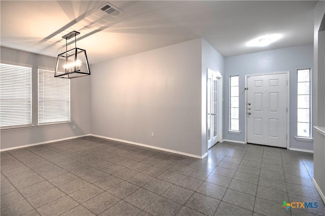 tiled entryway featuring a chandelier