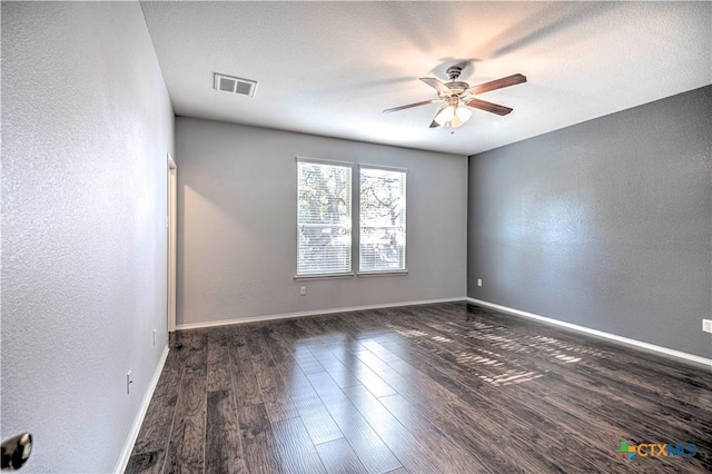 empty room featuring ceiling fan, dark hardwood / wood-style floors, and a textured ceiling