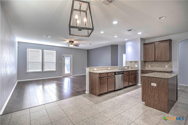 kitchen with light tile patterned flooring, pendant lighting, tasteful backsplash, dishwasher, and ceiling fan