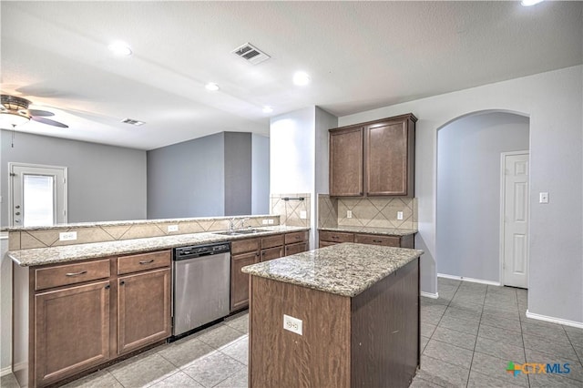 kitchen with dishwasher, decorative backsplash, a center island, ceiling fan, and kitchen peninsula