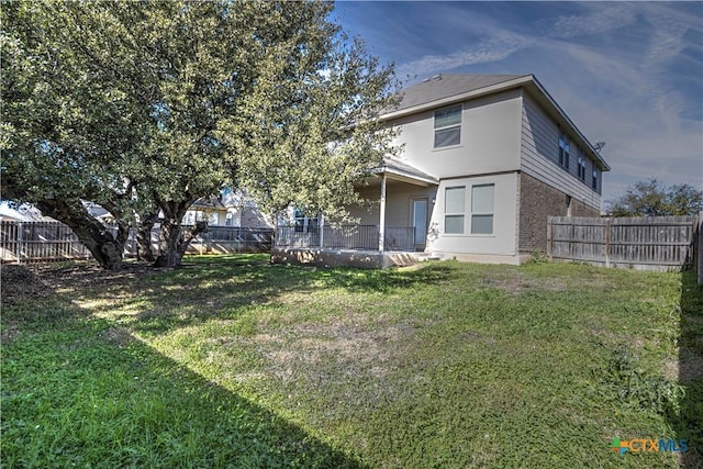 back of house featuring a lawn