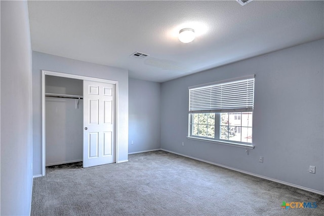 unfurnished bedroom featuring carpet floors and a closet