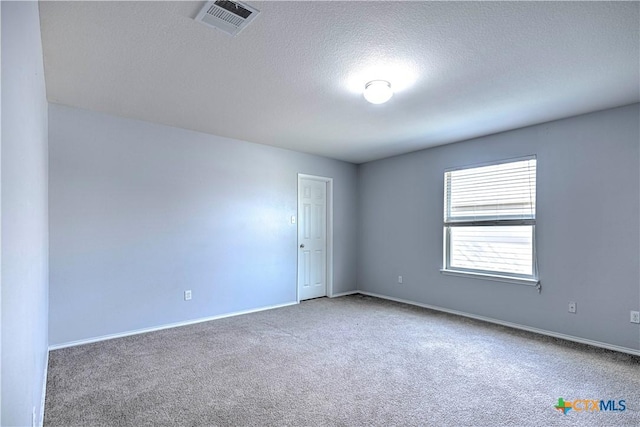 spare room featuring carpet flooring and a textured ceiling