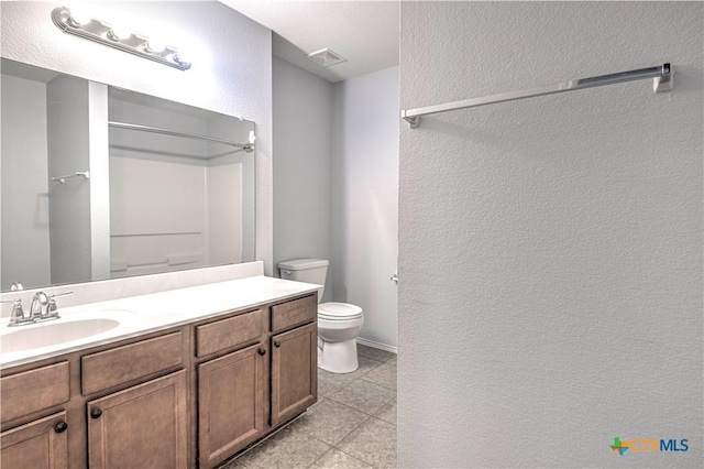 bathroom featuring vanity, tile patterned floors, and toilet