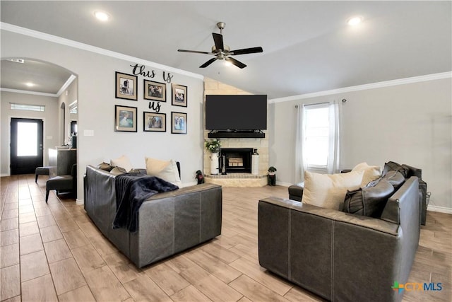 living room featuring crown molding, ceiling fan, a healthy amount of sunlight, and a fireplace