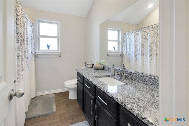 bathroom featuring lofted ceiling, vanity, toilet, and wood-type flooring