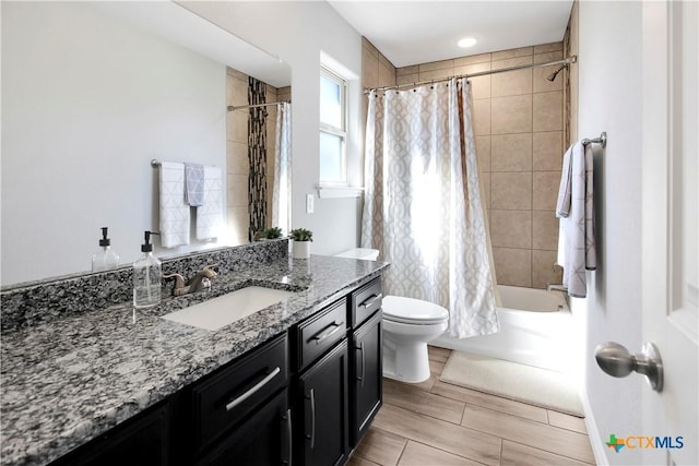 full bathroom featuring vanity, shower / bath combo with shower curtain, and toilet