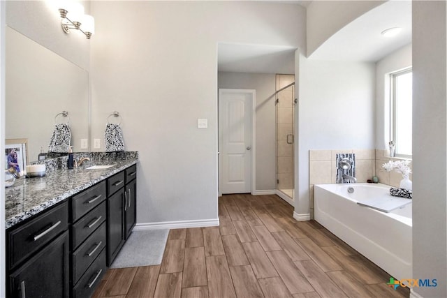 bathroom with vanity and shower with separate bathtub