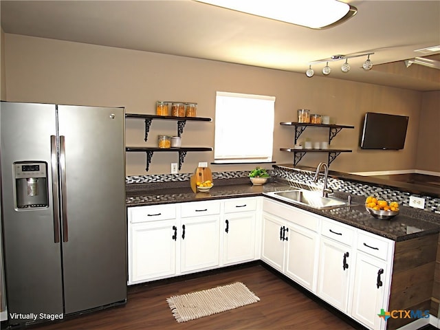 kitchen with dark hardwood / wood-style flooring, dark stone counters, sink, white cabinets, and stainless steel fridge with ice dispenser