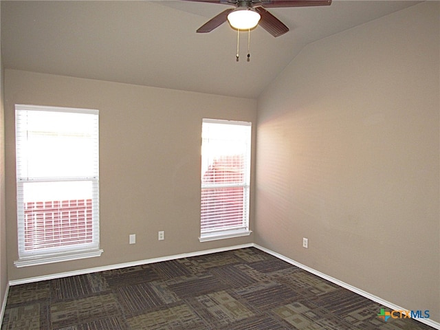 carpeted spare room featuring ceiling fan, plenty of natural light, and vaulted ceiling