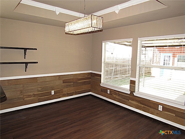 unfurnished dining area with a chandelier, wood-type flooring, and wood walls