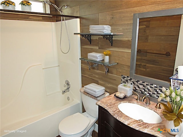 full bathroom with vanity, toilet, shower / bathtub combination, and wooden walls