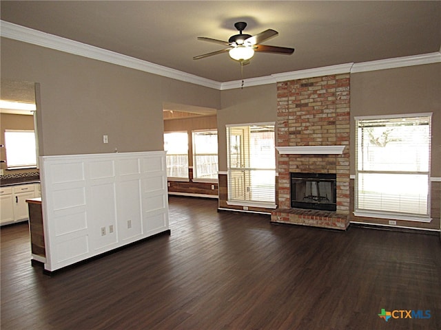 unfurnished living room featuring dark hardwood / wood-style floors, ceiling fan, ornamental molding, and a fireplace