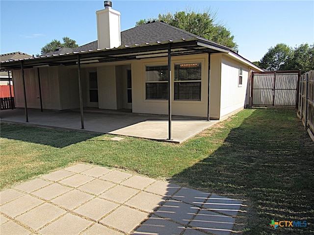 rear view of property with a yard and a patio area