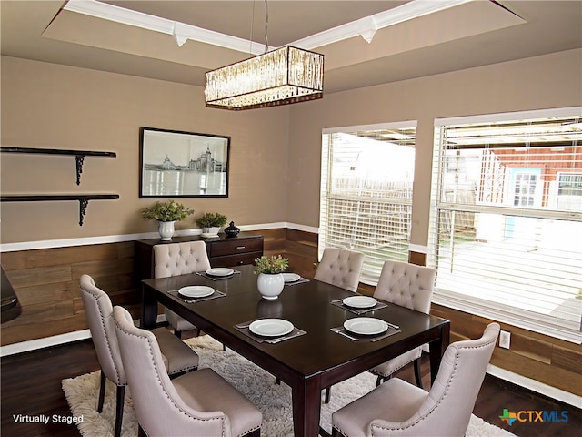 dining area with dark hardwood / wood-style flooring, crown molding, wooden walls, and an inviting chandelier