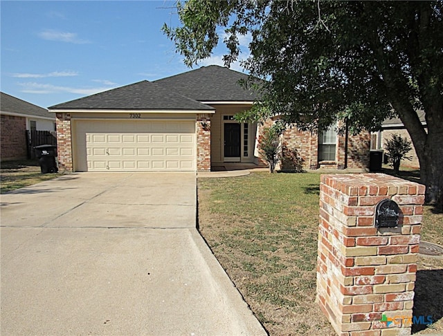 view of front of home with a front yard and a garage