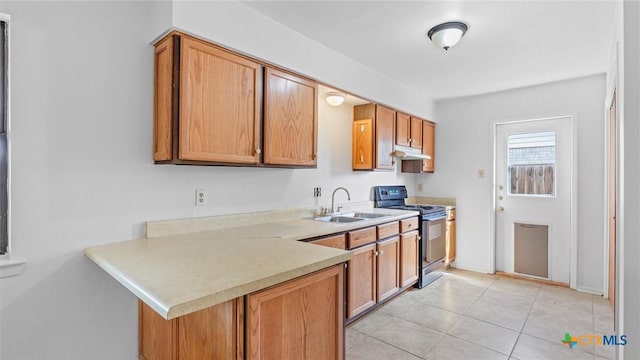 kitchen featuring electric range, under cabinet range hood, light countertops, brown cabinets, and a sink