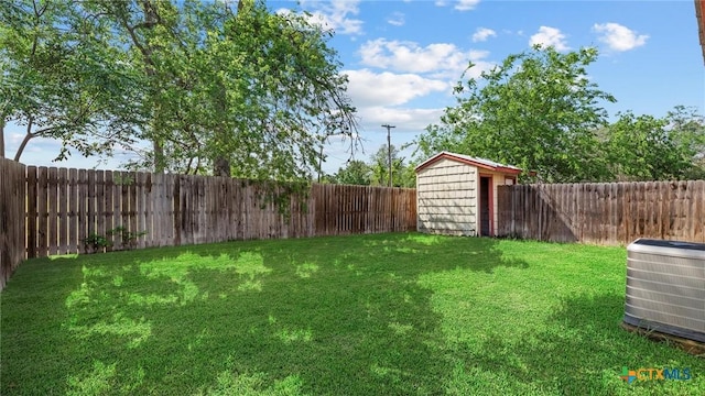 view of yard featuring central AC, a fenced backyard, an outbuilding, and a storage shed