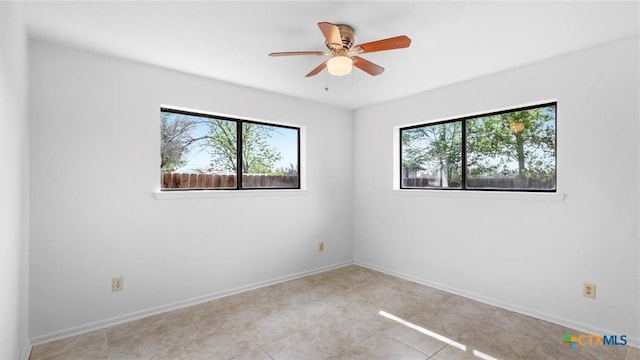 empty room with light tile patterned floors, ceiling fan, and baseboards