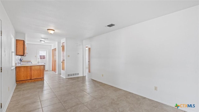 interior space featuring visible vents, brown cabinets, light countertops, and a sink