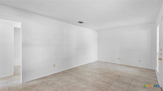 unfurnished room with visible vents