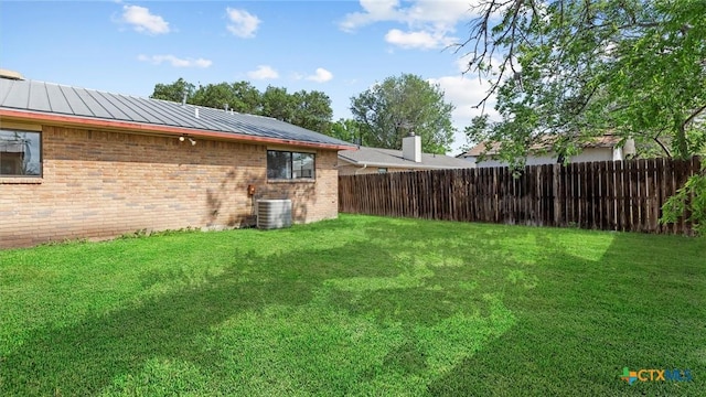 view of yard featuring fence and central AC unit