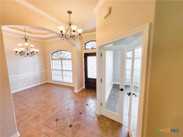 6409 Jovana Dr, Killeen, TX 76542 - entrance foyer with a chandelier, crown molding, light tile patterned floors, and arched walkways