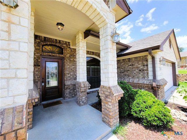 6409 Jovana Dr, Killeen, TX 76542 - property entrance with covered porch, stone siding, a garage, and brick siding