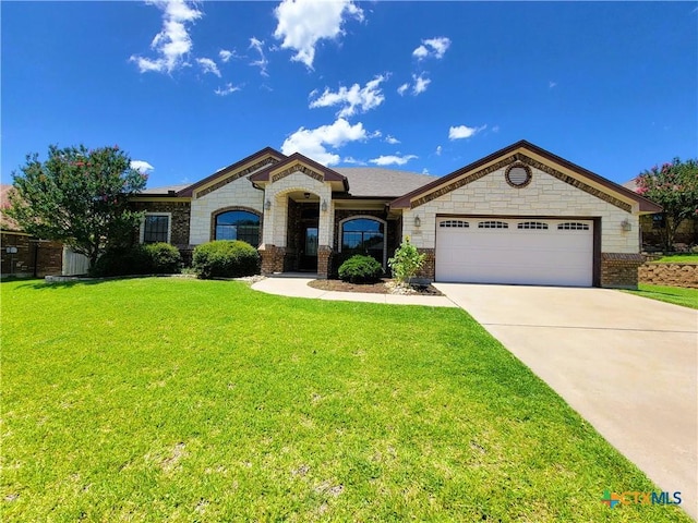 6409 Jovana Dr, Killeen, TX 76542 - french provincial home featuring a garage, concrete driveway, a front lawn, brick siding, and stone siding