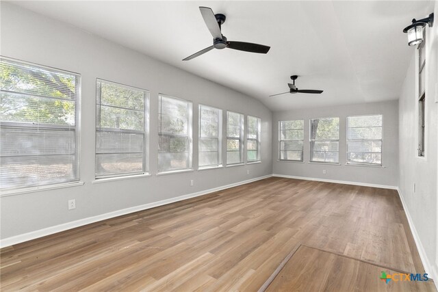 unfurnished sunroom featuring a wealth of natural light, ceiling fan, and vaulted ceiling