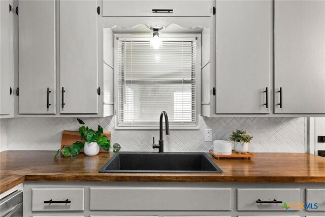 kitchen featuring butcher block counters, light wood-type flooring, appliances with stainless steel finishes, and gray cabinets