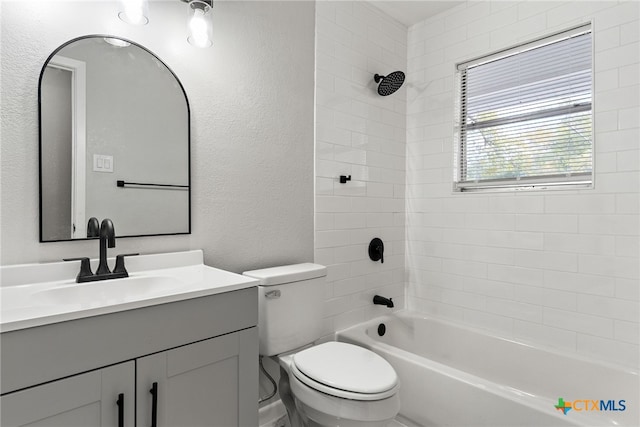 full bathroom featuring tiled shower / bath, toilet, and vanity