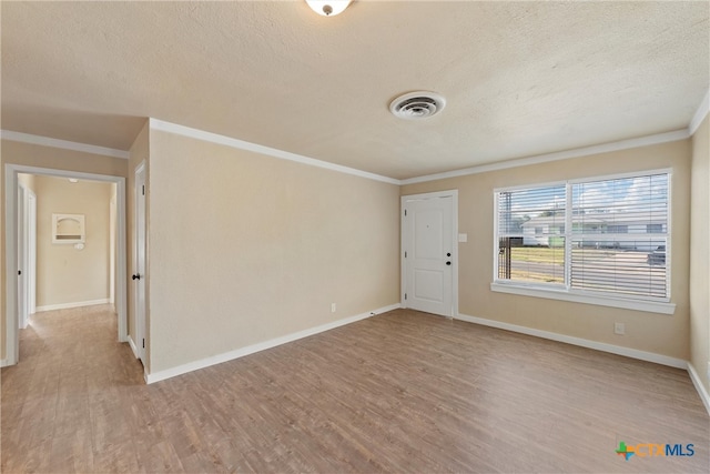 unfurnished room featuring ornamental molding, a textured ceiling, and light hardwood / wood-style floors