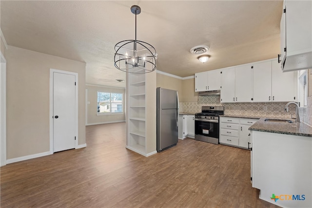 kitchen with hardwood / wood-style flooring, white cabinetry, sink, appliances with stainless steel finishes, and pendant lighting