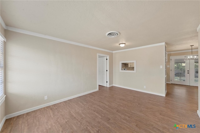 spare room featuring an inviting chandelier, dark hardwood / wood-style flooring, and ornamental molding