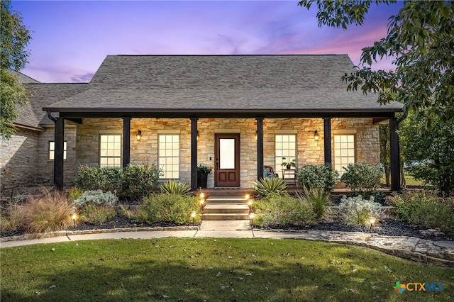 view of front of home with a porch and a yard