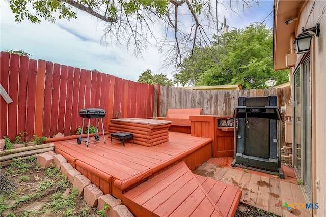 wooden terrace with a fenced backyard