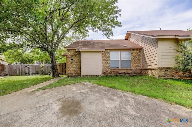 back of house featuring a yard, a patio, brick siding, and fence