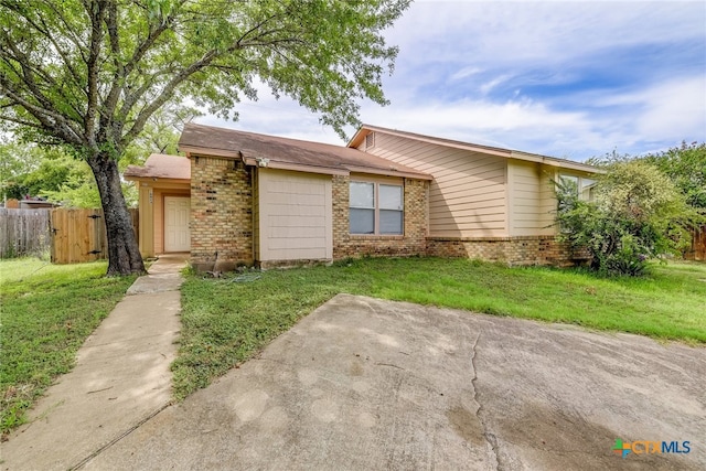 view of front of property with a front lawn, fence, and brick siding