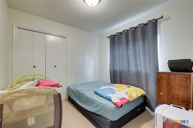 bedroom featuring a closet, a textured ceiling, and carpet