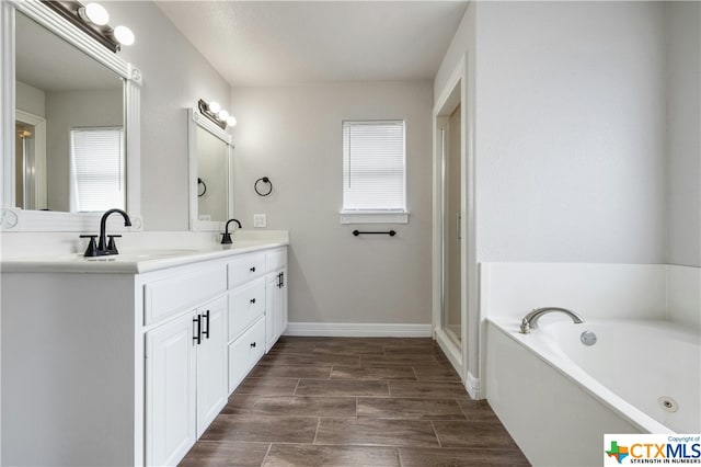 bathroom featuring a bathing tub, wood-type flooring, and vanity