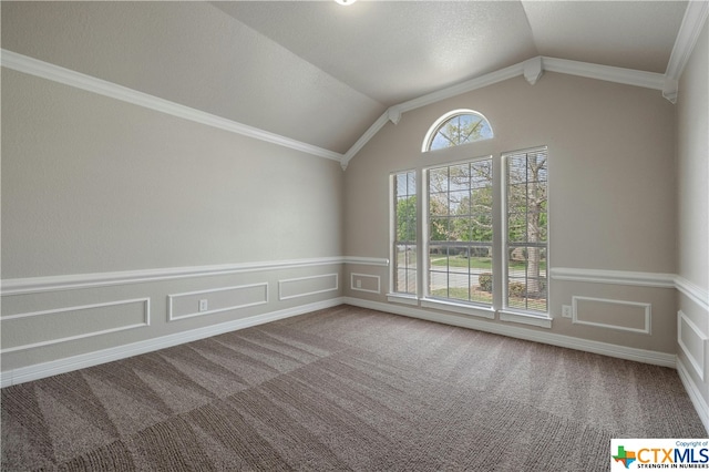 carpeted spare room featuring ornamental molding and lofted ceiling