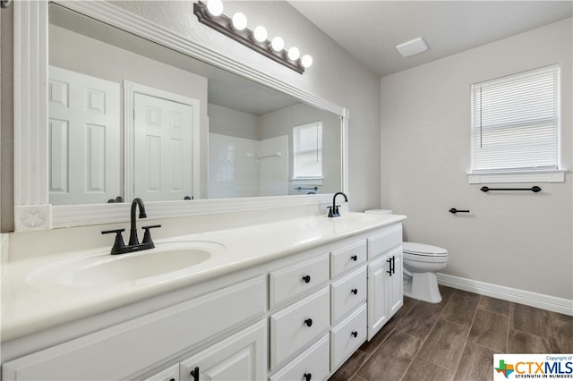 bathroom featuring vanity, hardwood / wood-style flooring, toilet, and a shower