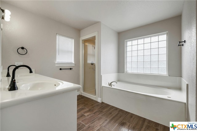 bathroom featuring shower with separate bathtub, vanity, wood-type flooring, and a textured ceiling