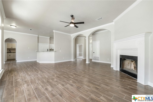 unfurnished living room with hardwood / wood-style floors, ceiling fan, and crown molding