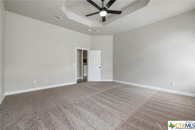 unfurnished room with carpet, ceiling fan, and a raised ceiling